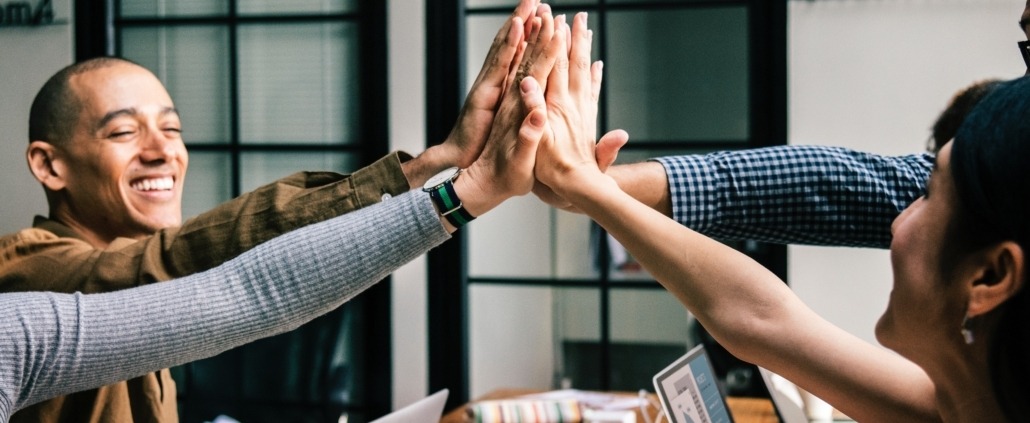 Group of business people high fiving each other