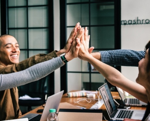 Group of business people high fiving each other
