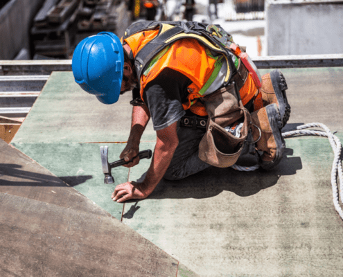 Construction worker hammering on a roof