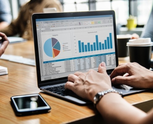 Woman using laptop with charts on the screen