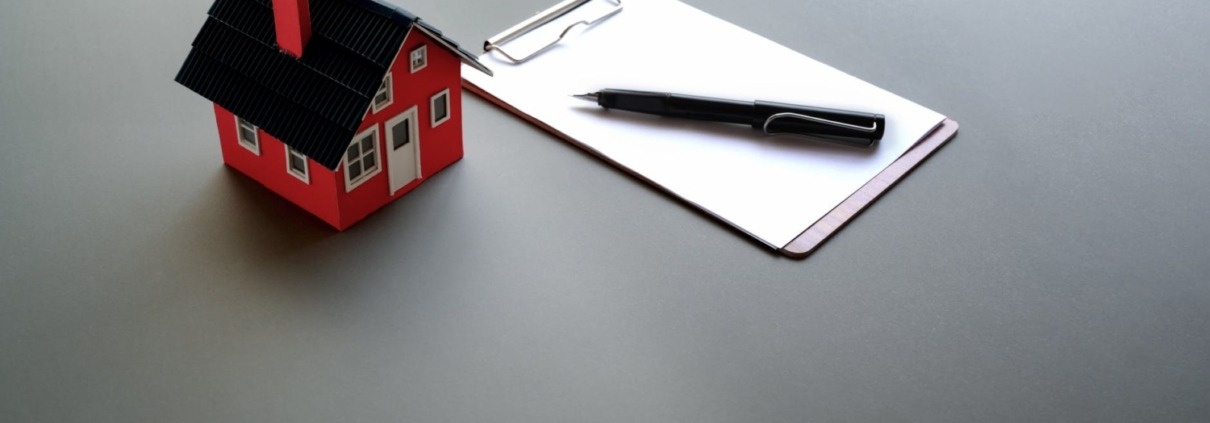 Model of small house beside clipboard