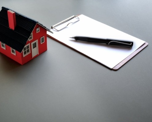 Model of small house beside clipboard