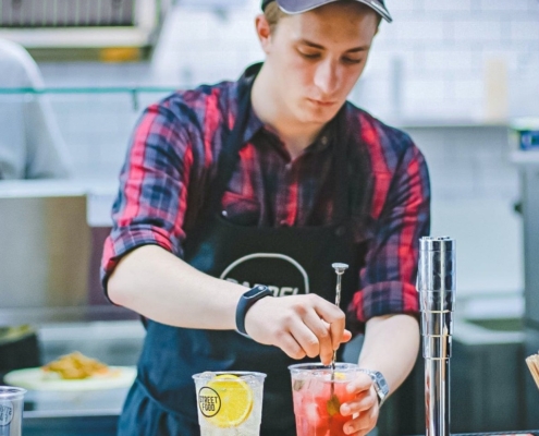 Young man mixing drinks in a cafe