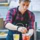 Young man mixing drinks in a cafe