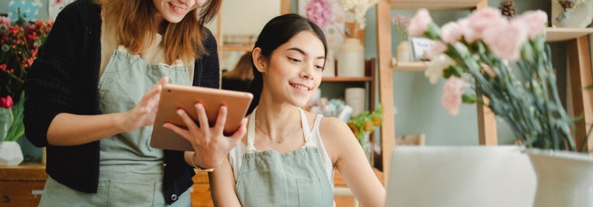 Two young women working on laptop and iPad in a flower shop