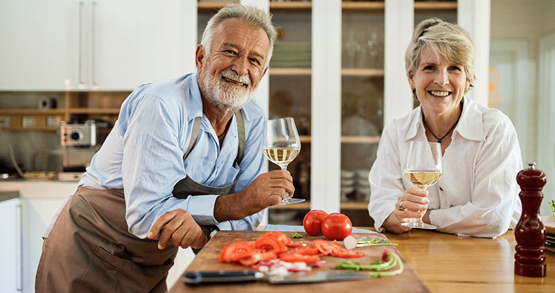 Older couple with glasses of wine in the kitchen